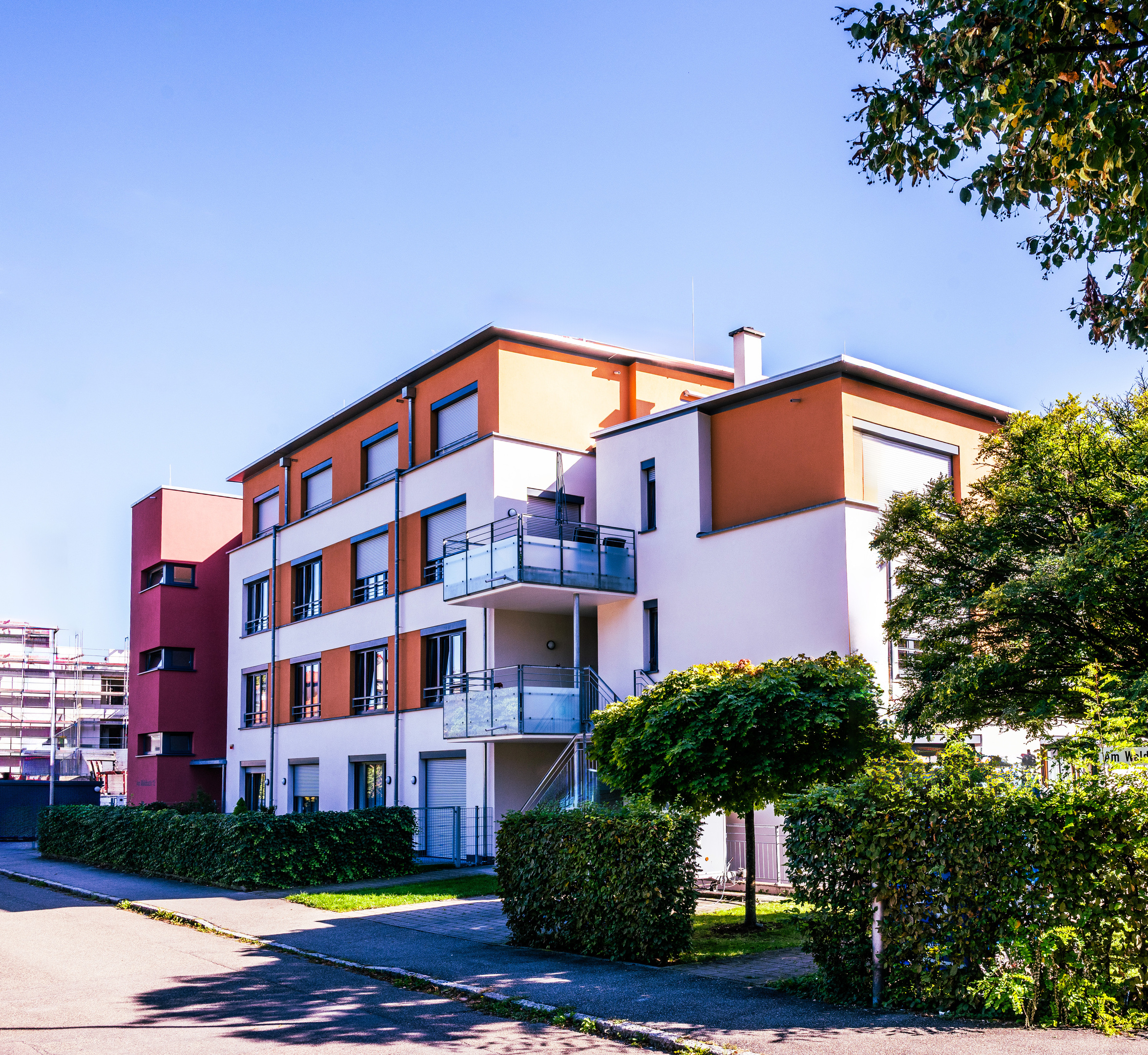 Ein Gebäude, das in drei Körper gegliedert ist. Links der vierstöckige Treppenturm, Mittig vier Stockwerke und rechts, um 90° gedreht, drei Stockwerke